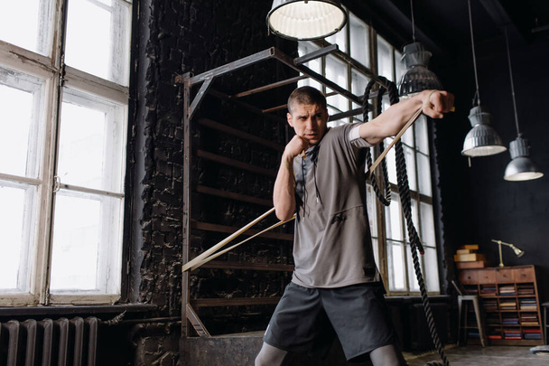 Крутой боец в боксерских повязках тренируется в спортзале. Смешанные боевые искусства - Фото, изображение
