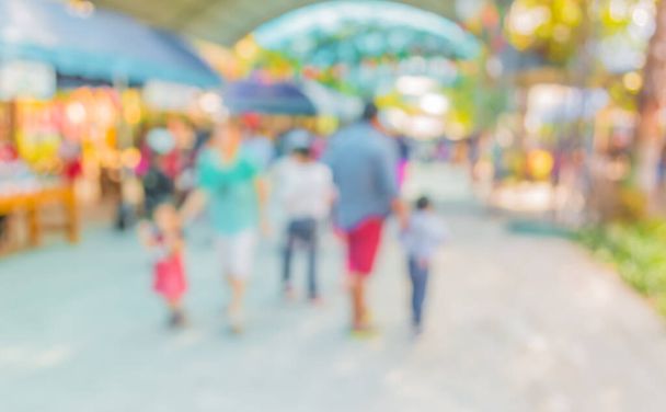 Blurred image of people walking at day market in sunny day, blur background with bokeh . - Photo, Image