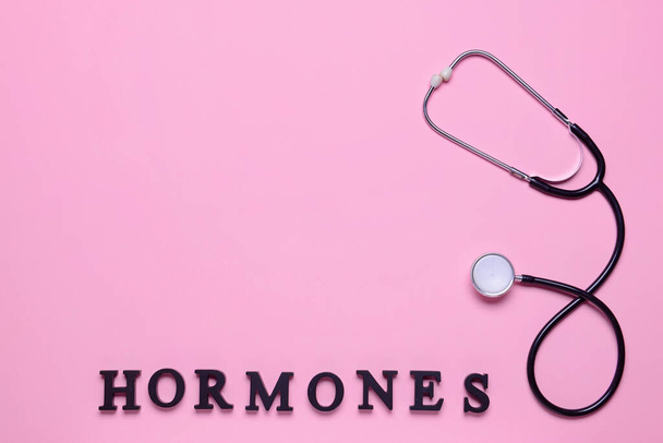 Mot HORMONES et stéthoscope sur fond de couleur - Photo, image