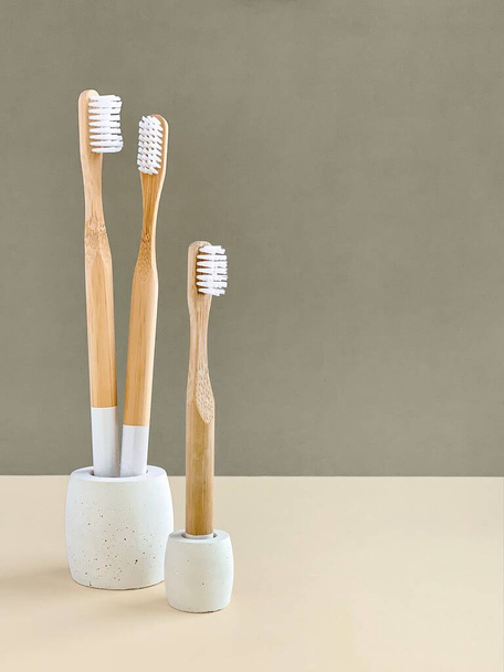 Cepillos de dientes de bambú en soportes de hormigón, accesorios de forma geométrica para fotografía de productos - Foto, Imagen