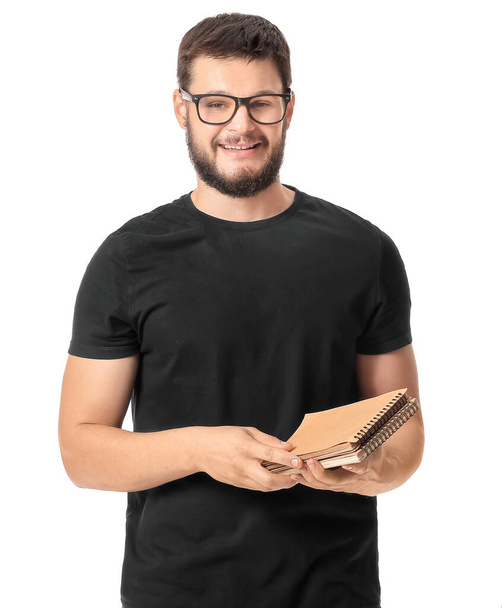 Portrait of young man with notebook on white background - Photo, Image