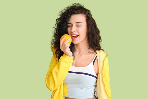 Portret stylowej młodej kobiety z pomarańczowymi owocami na tle koloru - Zdjęcie, obraz