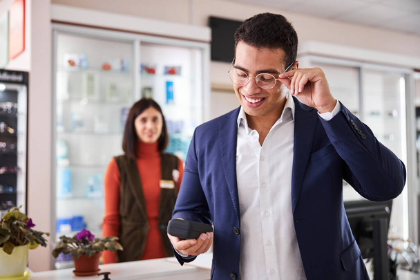 Cliente do sexo masculino se alegrando com sua compra em um escritório de óptica - Foto, Imagem