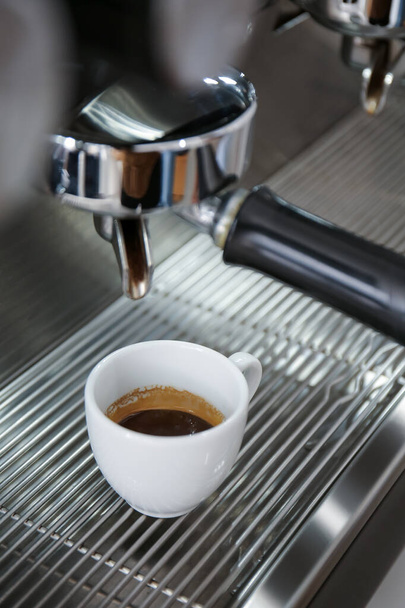 Nowoczesny ekspres do kawy z filiżanką gorącego espresso w kawiarni, zbliżenie - Zdjęcie, obraz