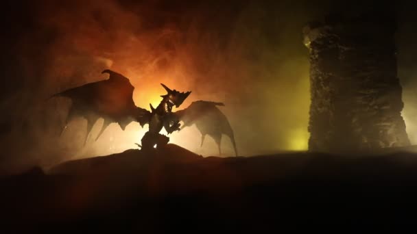 Silueta de dragón de fuego con grandes alas sobre un oscuro fondo de fuego ardiente. Enfoque selectivo - Imágenes, Vídeo