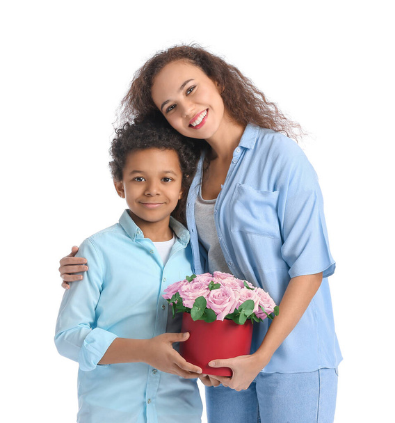 Beyaz arka planda çiçekli Afro-Amerikalı çocuk ve annesi - Fotoğraf, Görsel