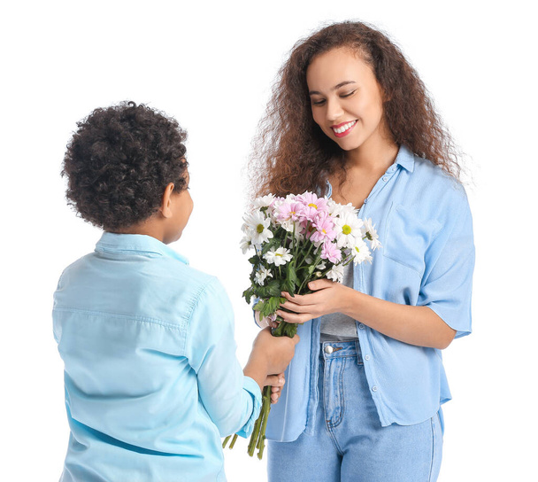 Menino afro-americano cumprimentando sua mãe com flores no fundo branco - Foto, Imagem