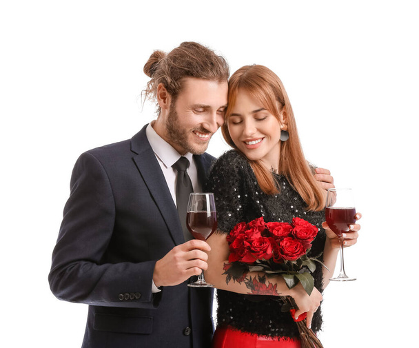 Junges Paar mit Blumen und Weingläsern auf weißem Hintergrund. Valentinstag-Feier - Foto, Bild