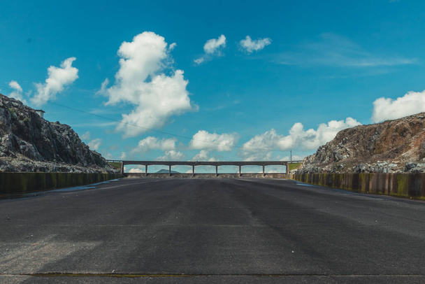 A stone-made bridge in an industrial area and an asphalt road under a beautiful cloudscape - Fotoğraf, Görsel