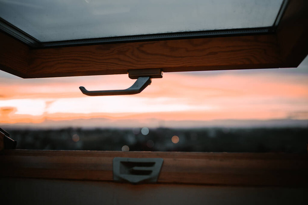 The beautiful sunset over a small city captured from a window - Foto, immagini