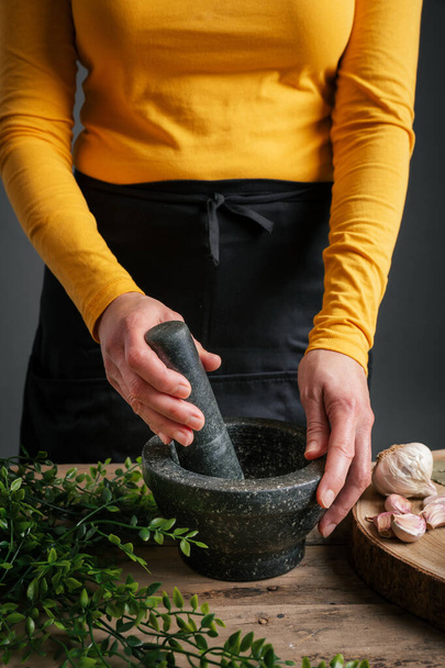 A female grinding pine nuts with mortar and pestle - Photo, Image