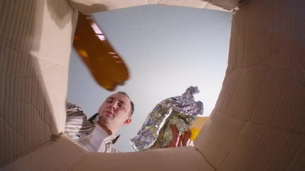 Video di uomo smistamento rifiuti di plastica, vista dal basso - Filmati, video