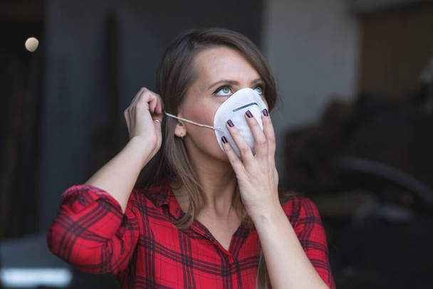 Young woman putting face mask for polluted air while exiting house - Фото, зображення