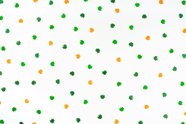 verde naranja y blanco trébol confeti escaso sobre fondo blanco  - Foto, Imagen
