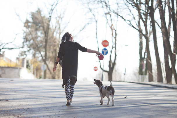 woman and her dog taking a walk - Фото, изображение