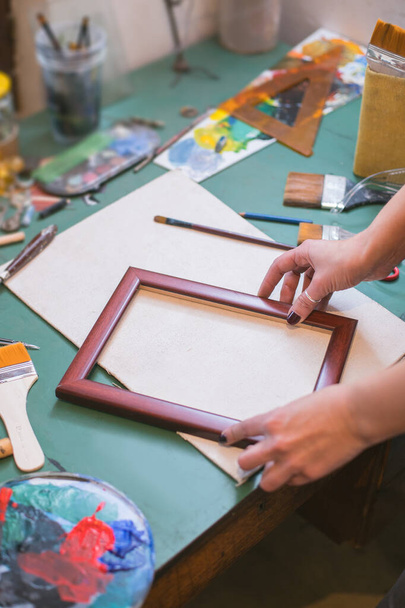 woman at painting studio holding a frame - Φωτογραφία, εικόνα
