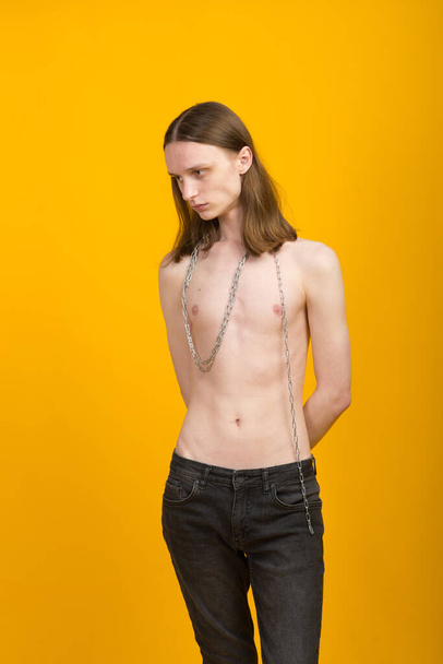 Vrouwelijke jongeman met metalen ketting. Slank lichaam, androgyne - Foto, afbeelding