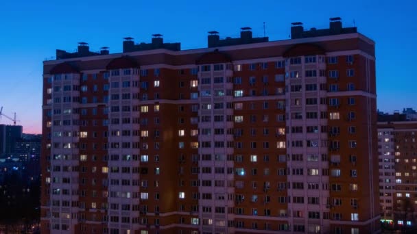 Alacakaranlıktan geceye kadar yaşayan apartman pencerelerinin zamanı - ön cephe manzarası - Video, Çekim