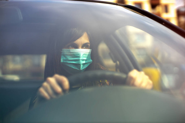 woman driving car with face mask - Foto, imagen