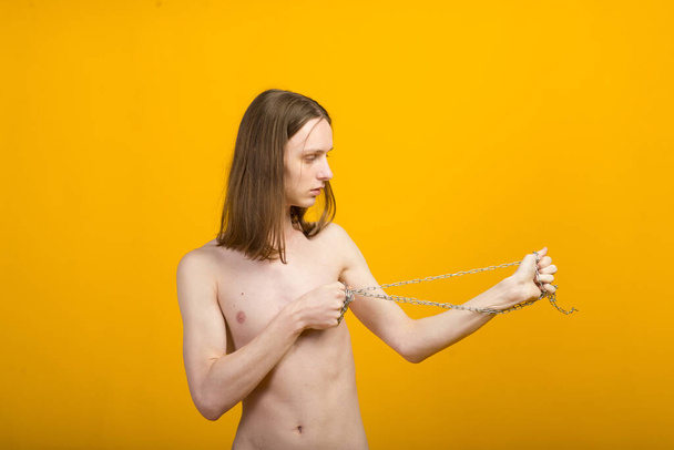 Joven femenino con cadena metálica. Cuerpo delgado, andrógino - Foto, imagen