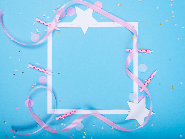 Party Holiday Hintergrund mit Schleife, Sternen, Geburtstagskerzen, Geschenkbox leeren Rahmen und Konfetti auf blauem Hintergrund. Studioaufnahme - Foto, Bild