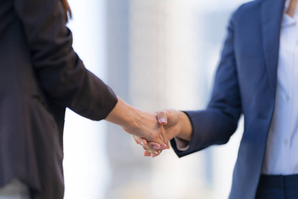 Close up, Handshake of two business women on the background of modern office, partnership concept, Shaking hands to seal a deal - Фото, зображення