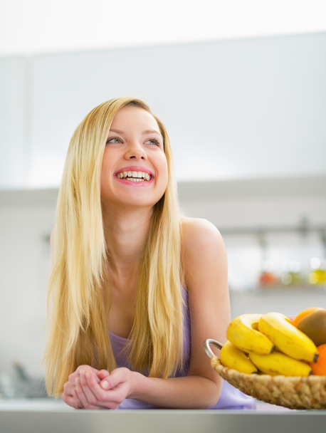 Smiling young woman in kitchen - Foto, afbeelding