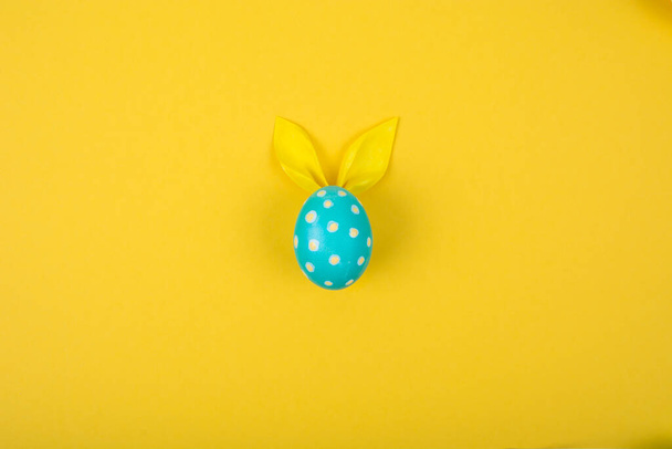 Eieren met papieren oren in de vorm van een paashaas. Gelukkige Pasen Concept Card Postaer Achtergrond. Foto van de studio - Foto, afbeelding