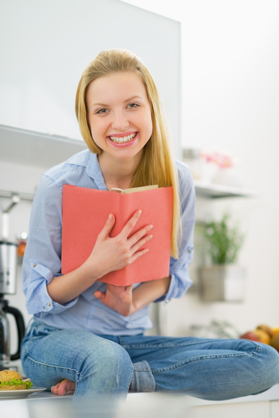 Woman reading book in kitchen - Photo, Image