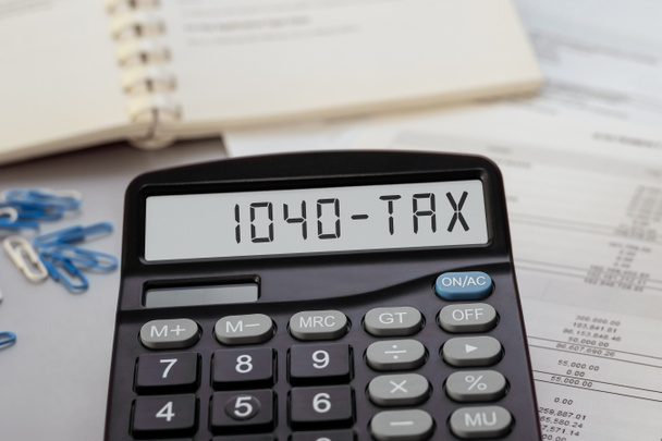 Taschenrechner mit dem Wort 1040-Steuer im Display. Unternehmens-, Steuer- und Finanzkonzept - Foto, Bild