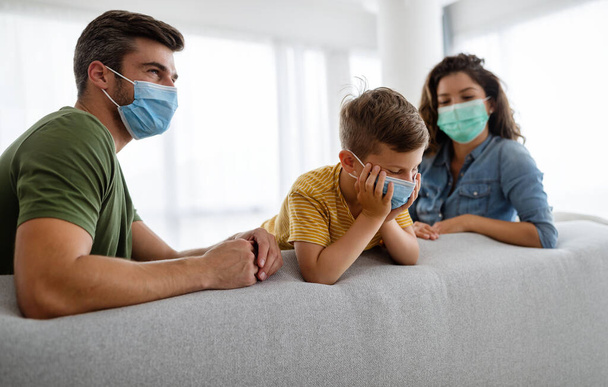 Beautiful young family wearing face masks against coronavirus world pandemic and staying home - Φωτογραφία, εικόνα
