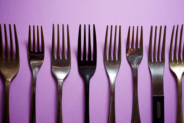 Colección de tenedores sobre una mesa púrpura. - Foto, imagen