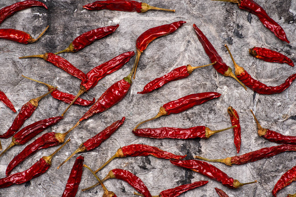 Ξηρές κόκκινες πιπεριές σε πέτρινο τραπέζι - Φωτογραφία, εικόνα