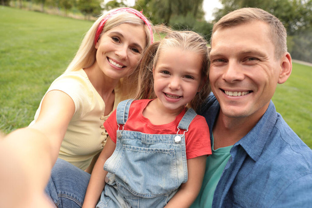 Happy family taking selfie in park on summer day - Фото, изображение