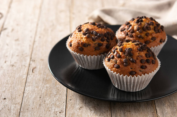 Just baked chocolate muffins on wooden table - Photo, Image
