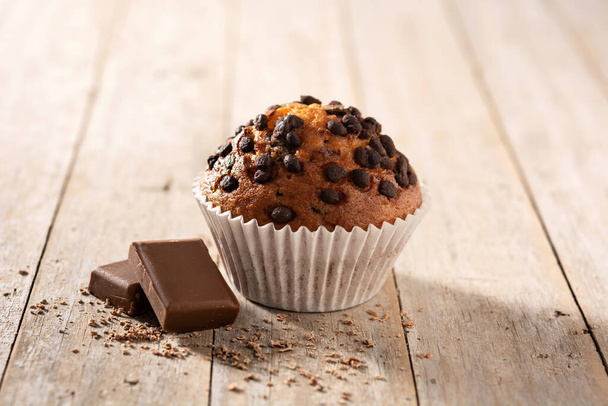 Právě upečený čokoládový muffin na dřevěném stole - Fotografie, Obrázek