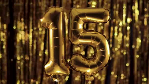 Oro número 15 quince de un globo inflable, sobre fondo amarillo. Uno de los números completos. El concepto de cumpleaños, aniversario, fecha - Metraje, vídeo