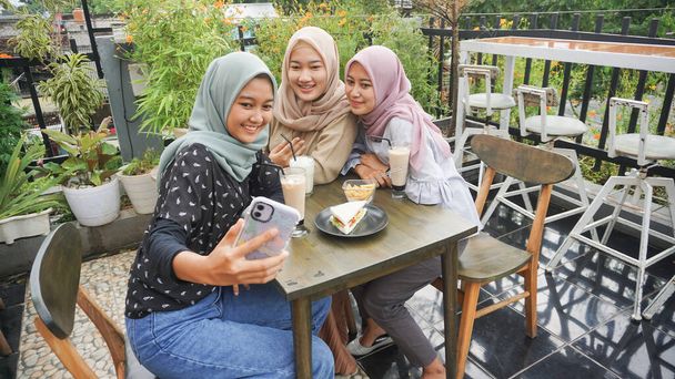 Asian hijab woman group selfie in cafe with friend - Photo, Image