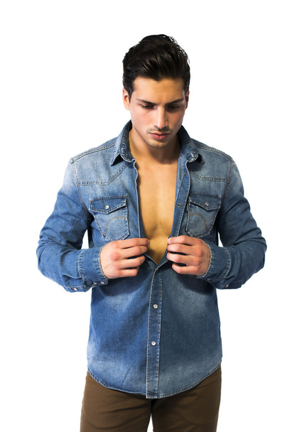 Latin young man opening denim shirt on naked chest - Foto, afbeelding