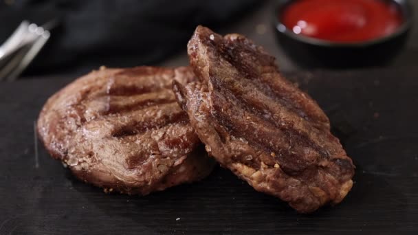 salt falling on freshly grilled beef fillet steak on black stone restaurant plate - Footage, Video