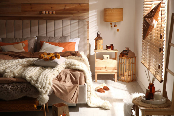 Cozy bedroom interior with knitted blanket and cushions - Fotografie, Obrázek