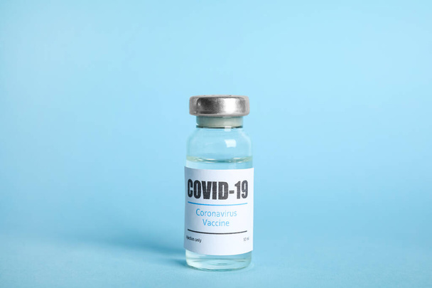 Vial with coronavirus vaccine on light blue background - Fotó, kép