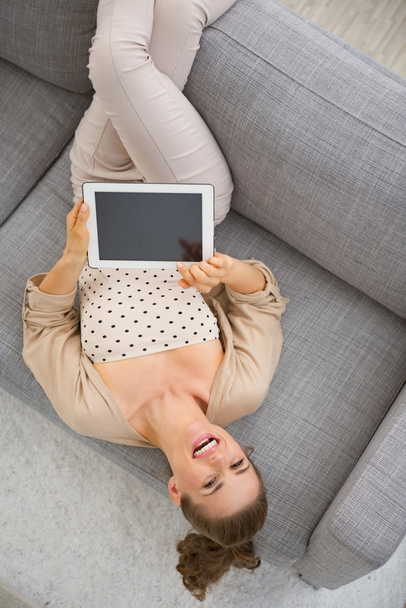 Smiling woman on couch with tablet - Foto, afbeelding
