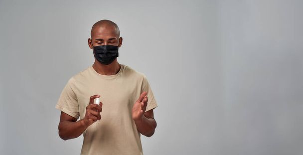 Man spraying his palm with an antiseptic - Photo, image