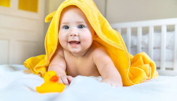 Baby na het baden in een handdoek. Selectieve focus. Mensen. - Foto, afbeelding