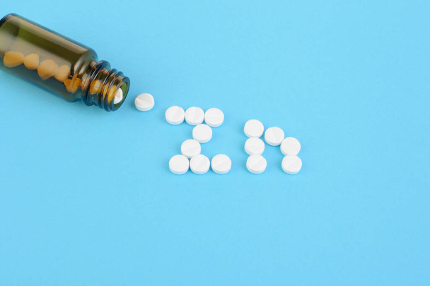 青い背景に白い錠剤と医療用ボトルの創造的なコンセプト写真,ビタミン亜鉛,錠剤が並ぶ文字,漢方薬 - 写真・画像