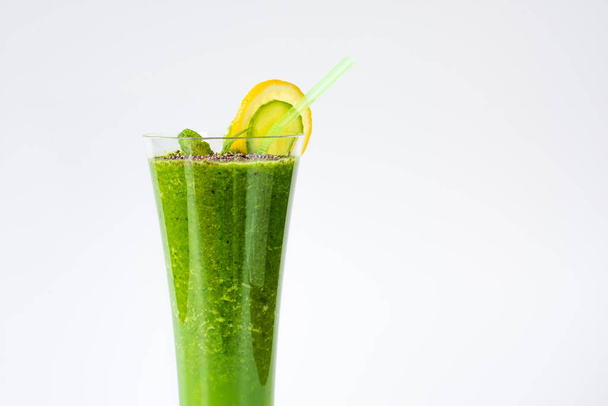 Une boisson saine mélangée à des fruits et légumes verts est préparée devant le mur, servie avec des graines de chia. avec contenu - Photo, image