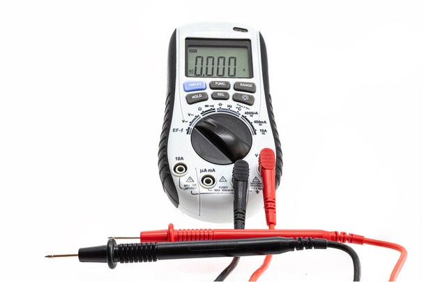 multímetro digital com sondas de ensaio, na posição de leitura da tensão CA e no visor ligado, marcando uma leitura de zero volts - Foto, Imagem