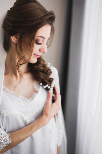 Bella sposa indossa abito da sposa di moda con piume con lusso delizia make-up e acconciatura, servizio fotografico indoor studio - Foto, immagini