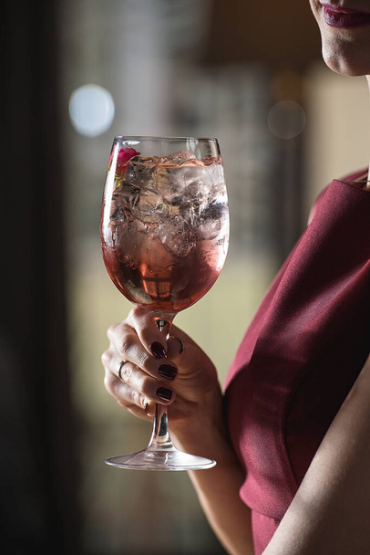 femme tient coctail rose alcoolique relaxant avec une rose sur le dessus - Photo, image